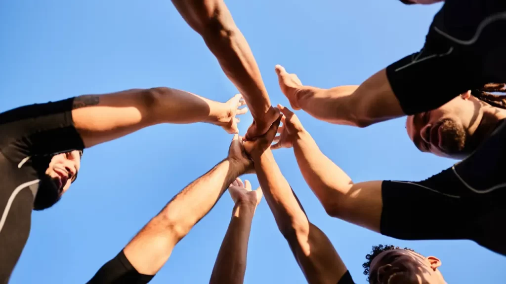 Team building: o que é e como aplicar na sua equipe de atendimento? Equipe colaborando para o team building