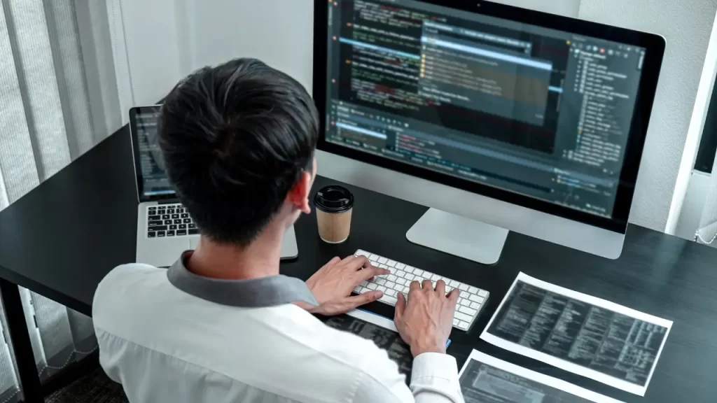 Base de conhecimento: porque ela é essencial no suporte ao cliente Homem trabalhando no computador em base de conhecimento