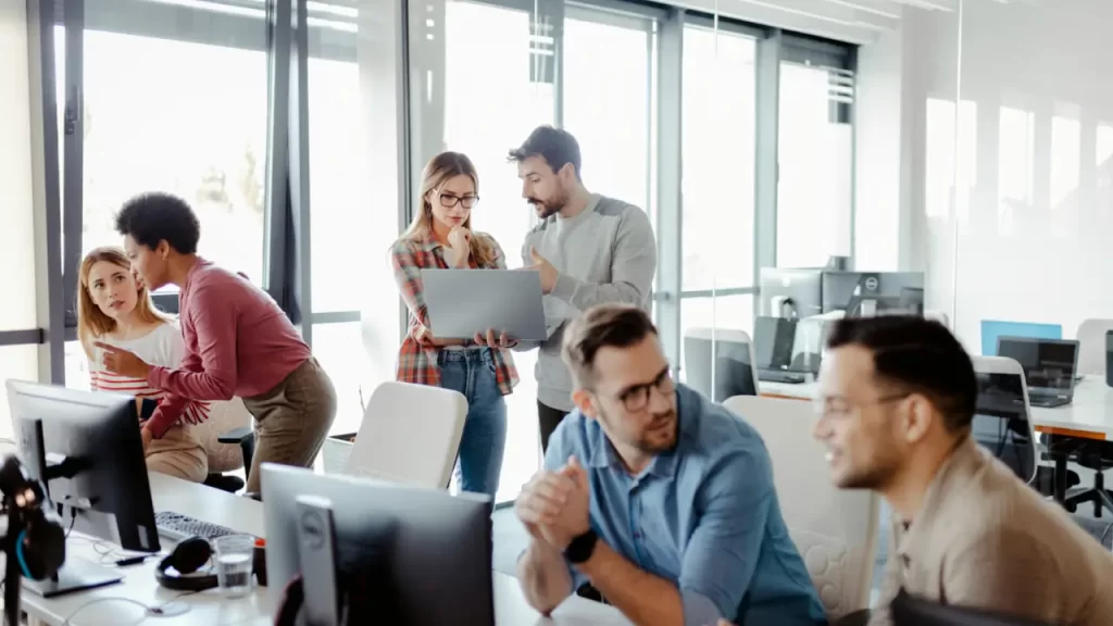 A imagem mostra uma equipe de outsourcing trabalhando em um escritório.