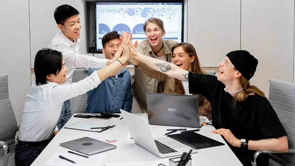 Silos organizacionais: o que são e como evitá-los Pessoas comemorando sucesso de silos organizacionais